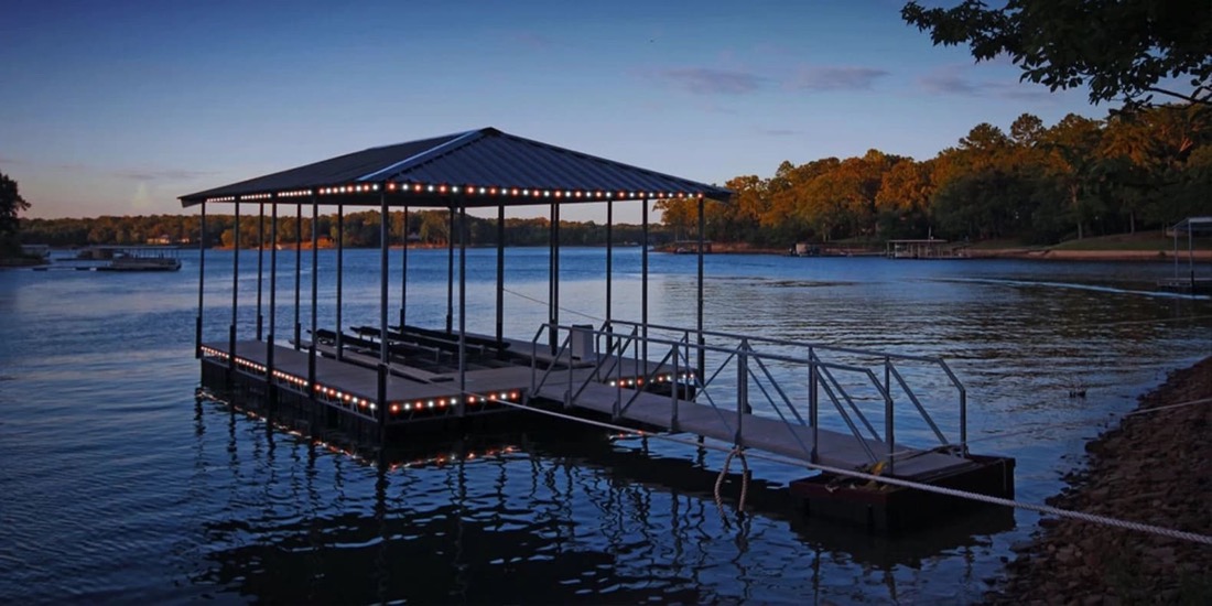 Covered lake dock with permanent accent lighting along the roofline and railing
